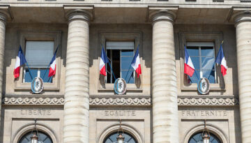 French flags outside windows above the words liberty, equality and fraternity